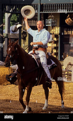 wild-west-cowboy-on-a-horse-waving-his-hat-at-the-knotts-berryfarm-C7FXMT